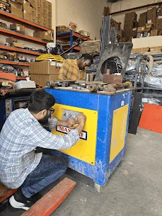 Technician working on the control panel of a bar bending machine in the AMACO Ajman workshop